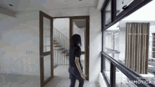 a woman in a black shirt is standing in a room with a staircase in the background and made in animatica