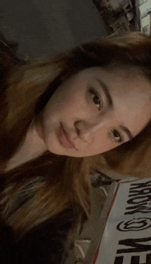 a close up of a woman 's face with a sign in the background that says ' nikon '