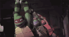 a group of teenage mutant ninja turtles are hanging upside down from a ceiling .