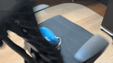 a person is sitting on a chair with a blue pillow on the arm rest