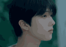 a close up of a young man 's face with short hair .