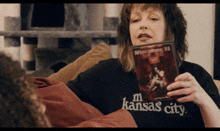 a woman sitting on a couch holding a dvd of witchcraft ii