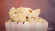 a poster for freakier friday shows a pile of popcorn on a pink fence