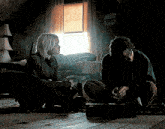 a man and a woman are sitting on the floor talking
