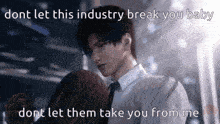 a man in a suit and tie is hugging a woman with the words `` dont let this industry break you baby '' written on the bottom