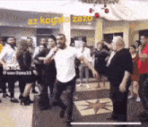 a group of people are dancing in a room with a man holding a microphone .