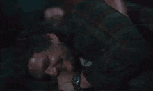 a man is laying on the floor with blood on his face and a watch on his wrist .