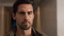 a man with a beard and long hair is looking at the camera
