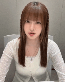 a woman with braids on her hair is wearing a white top