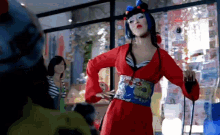 a woman in a red dress is dancing in a room