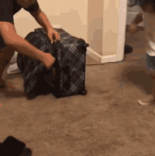 a man is packing a suitcase while a child watches