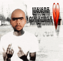 a man in a white shirt is giving the middle finger in front of a red heart that says ' broken heart '
