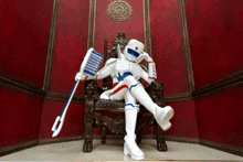 a robot is sitting on a chair holding a toothbrush