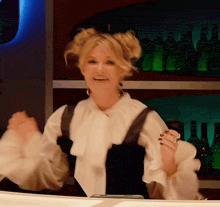 a woman in a white blouse is dancing in front of a bar