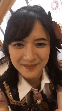 a close up of a woman 's face with her eyes closed and a smile on her face .
