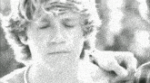 a black and white photo of a young man with a sad look on his face