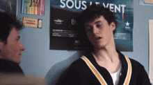 two young men are standing in front of a poster that says sous vent on it