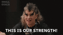 a woman with a mohawk and a chain around her neck is saying this is our strength