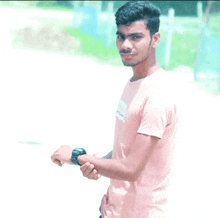 a young man wearing a pink t-shirt with the word tommy on it