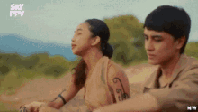 a man and a woman are sitting next to each other in a field with sky ppv written on the bottom