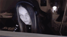 a woman wearing headphones is sitting in front of a computer monitor .