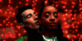a man and a woman are standing next to each other with red lights in the background