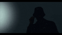 a silhouette of a man wearing a bucket hat with the word gucci on it