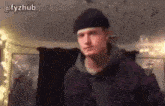 a man wearing a beanie and a hoodie is standing in a room with a watermark that says @fyzhub