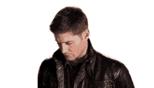 a man wearing a black leather jacket is looking at the camera .