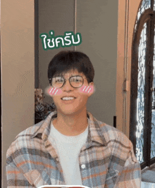 a man wearing glasses and a plaid shirt has a sticker on his face that says ' i 'm happy '