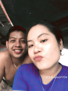 a man and a woman are posing for a picture and the woman is wearing a blue shirt with anne071724 on it