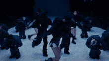 a group of people are dancing in a dark room with their arms outstretched