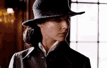 a close up of a woman wearing a hat and a coat .