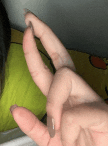 a close up of a person 's hand with a ring on it