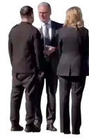 a man in a suit and tie is talking to two other people