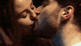 a man and a woman are kissing in a dark room