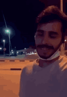 a man with a beard wearing a white shirt and a mask on his face