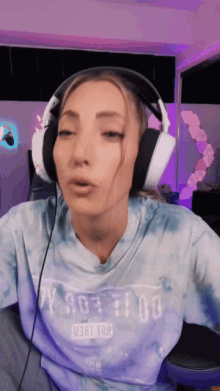 a woman wearing headphones and a tie dye shirt that says right tow on it