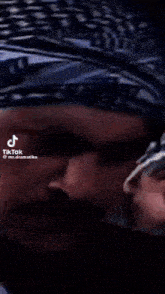 a close up of a man 's face with arabic writing on the bottom of it