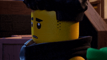 a close up of a lego character with a scarf around his neck making a sad face