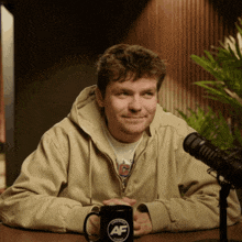 a man sits at a table with a mug that says af