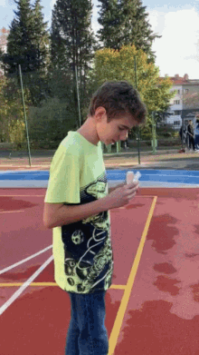 a young boy wearing a neon green shirt is standing on a basketball court