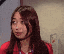 a woman in a red shirt has a lanyard around her neck that says ' one '