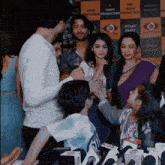 a group of people are standing in front of a wall that says dkp shahi production production production