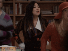 a woman in a red hat is dancing with other women
