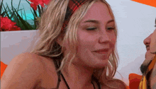 a woman wearing a plaid headband and a nose ring looks at a man