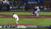 a baseball game is being played with an ad for geico in the outfield
