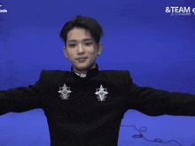 a man with his arms outstretched in front of a blue background that says & team e