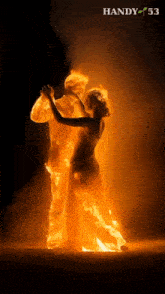 a man and a woman are dancing in flames with the handy 53 logo in the corner