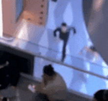 a blurry picture of a person standing on a balcony with a blue background .
